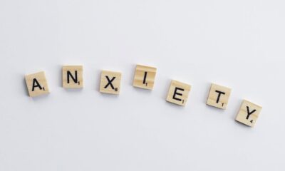 Wooden tiles on a white background spell anxiety, symbolizing mental health awareness.