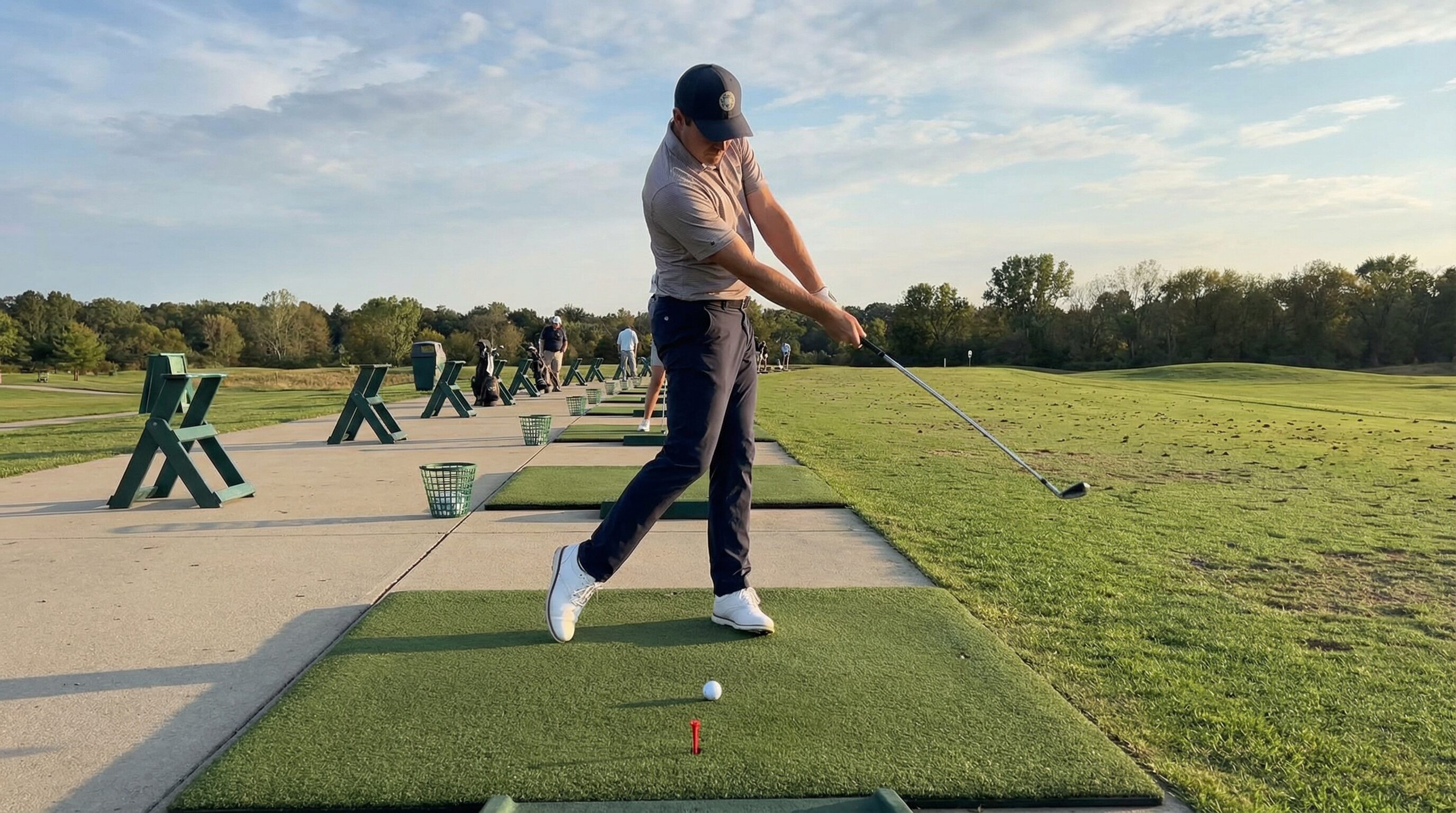 A golfer demonstrating proper weight transfer with a tee drill, showing the low point ahead of the ball.