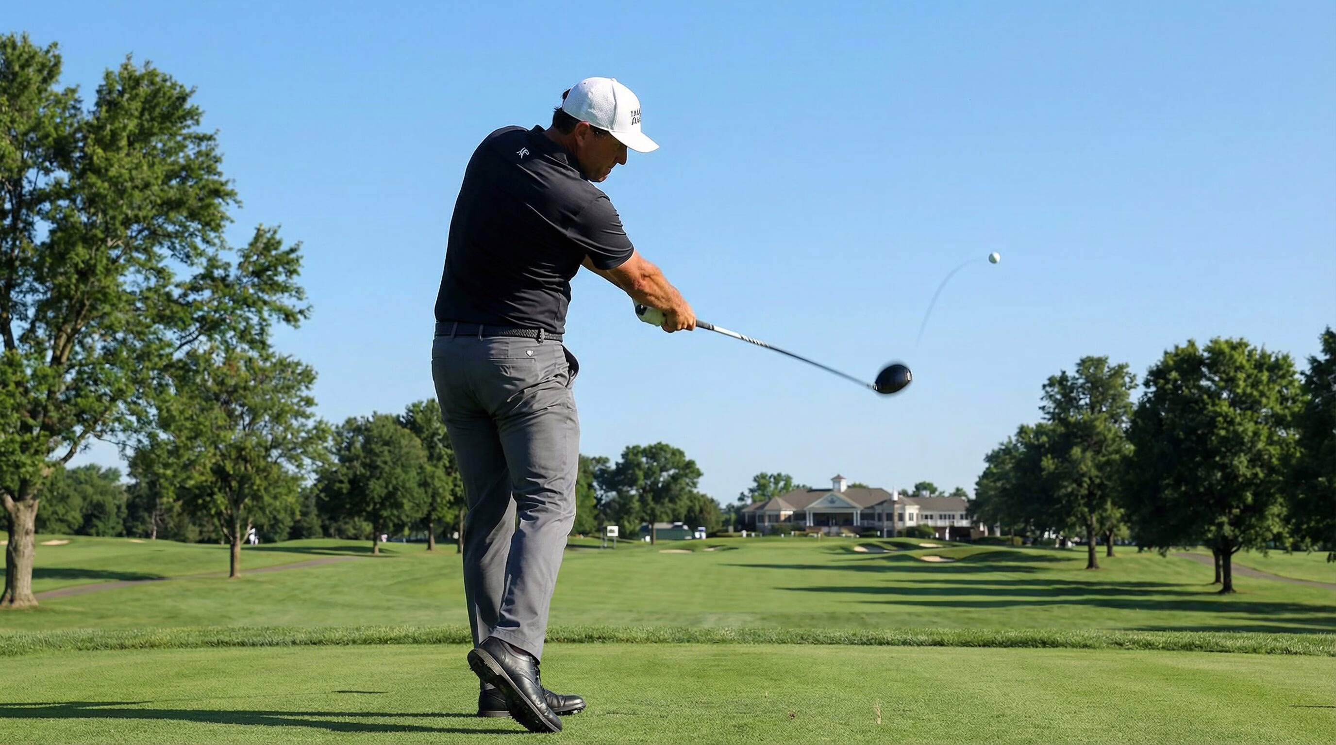 Golfer hitting a powerful draw with a driver on a championship course.