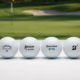 A lineup of premium golf balls from Titleist, Callaway, Srixon, TaylorMade, Bridgestone, and Mizuno on a white surface with a golf course in the background