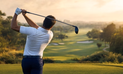 How to Hit a Draw — hero image showing a golfer at the top of the backswing from a down-the-line view