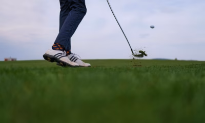 Golfer striking an iron shot during a golf fitness workout performance session.