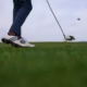 Golfer striking an iron shot during a golf fitness workout performance session.