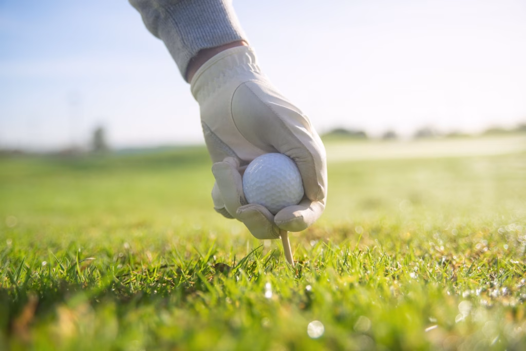 Presidents Cup 2026 team match play odds perspective, a gloved hand places a golf ball on a tee.