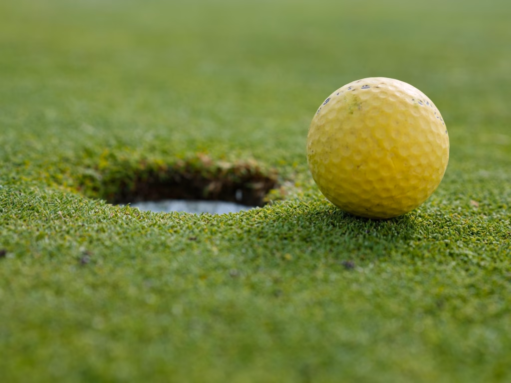 Presidents Cup 2026 odds analysis, a golf ball sits beside the hole on a shallow-focus green.