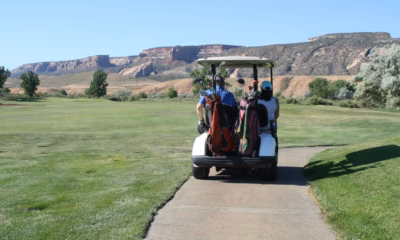 Two golfers riding a cart along a course path, illustrating golf scramble rules etiquette.